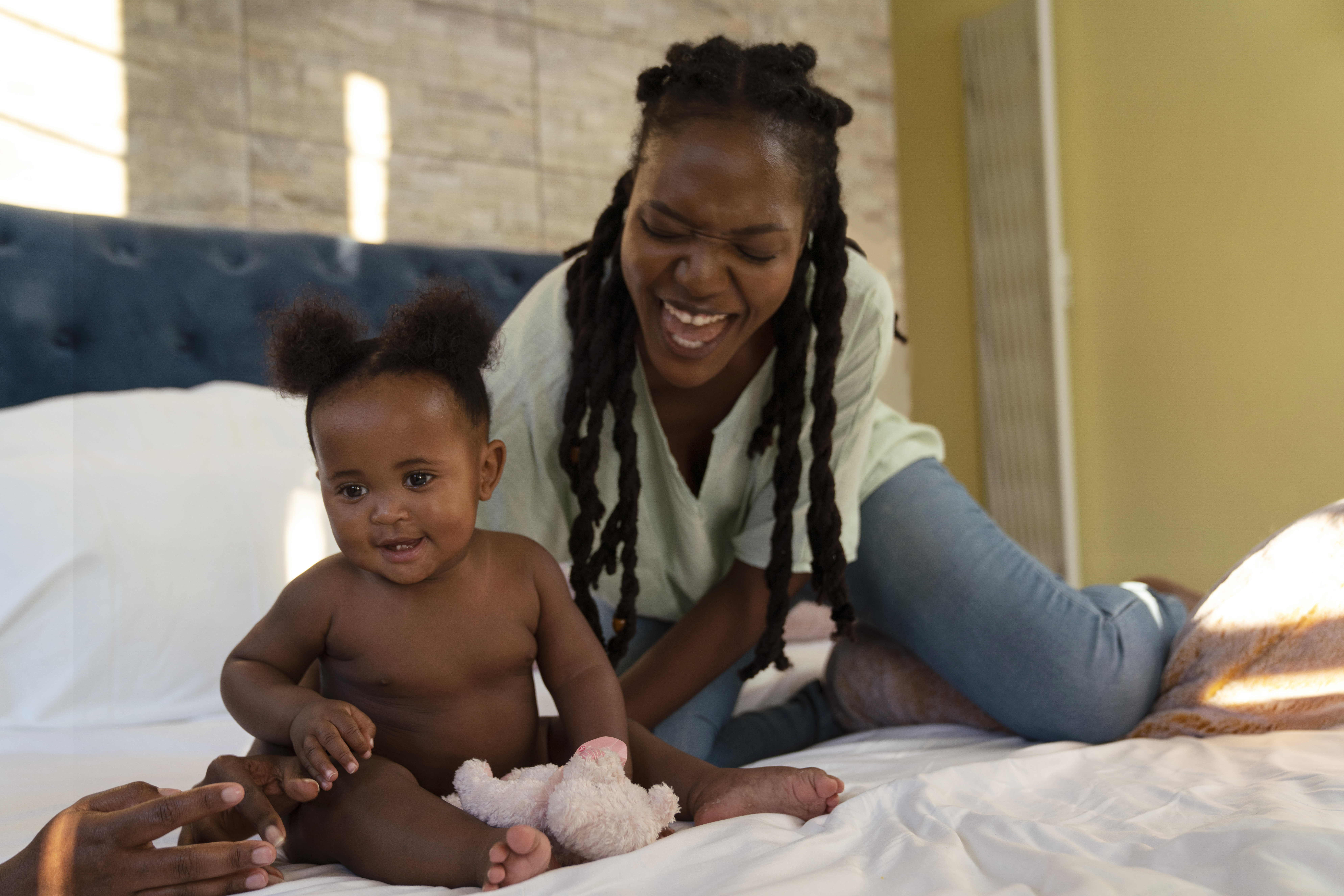Happy mother and baby with professional nurse at home